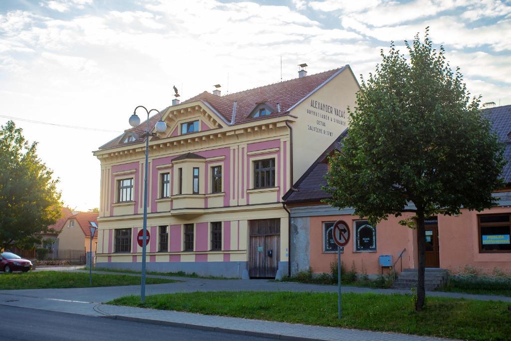 Vagačov dom في ديتفا: مبنى وردي وبيض على جانب شارع