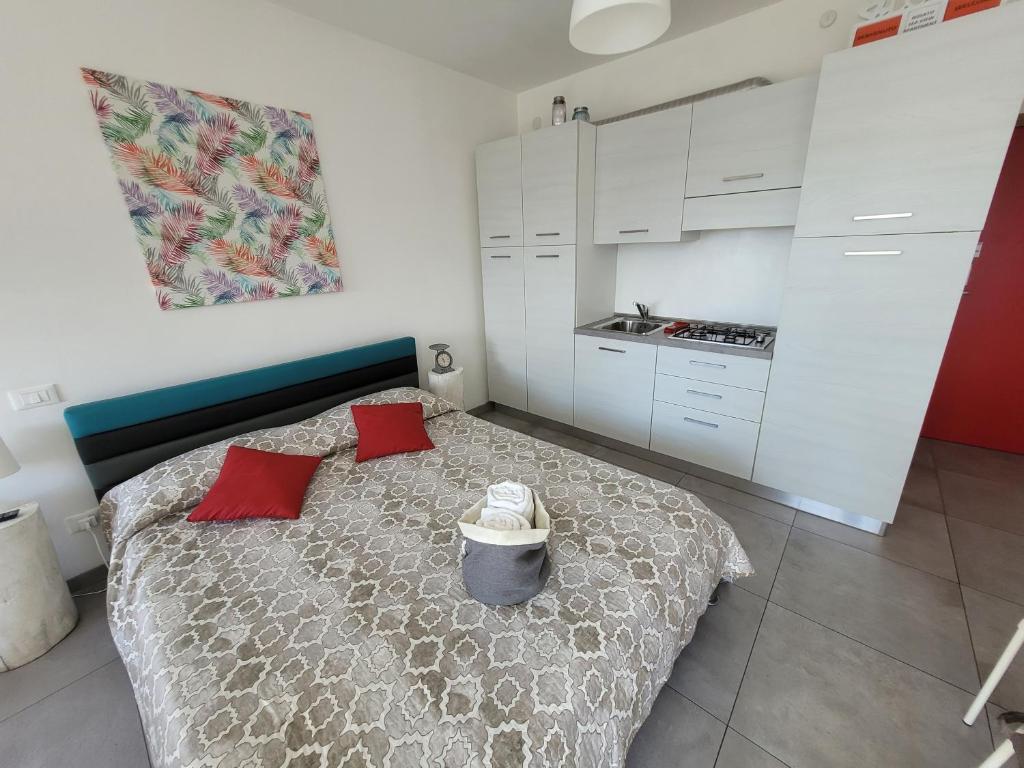una camera con un letto con due cuscini rossi di Rosato Sea View Apartment a Lignano Sabbiadoro
