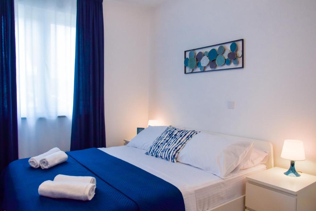 - une chambre avec un lit et 2 serviettes dans l'établissement Locus Apartments, à Petrčane