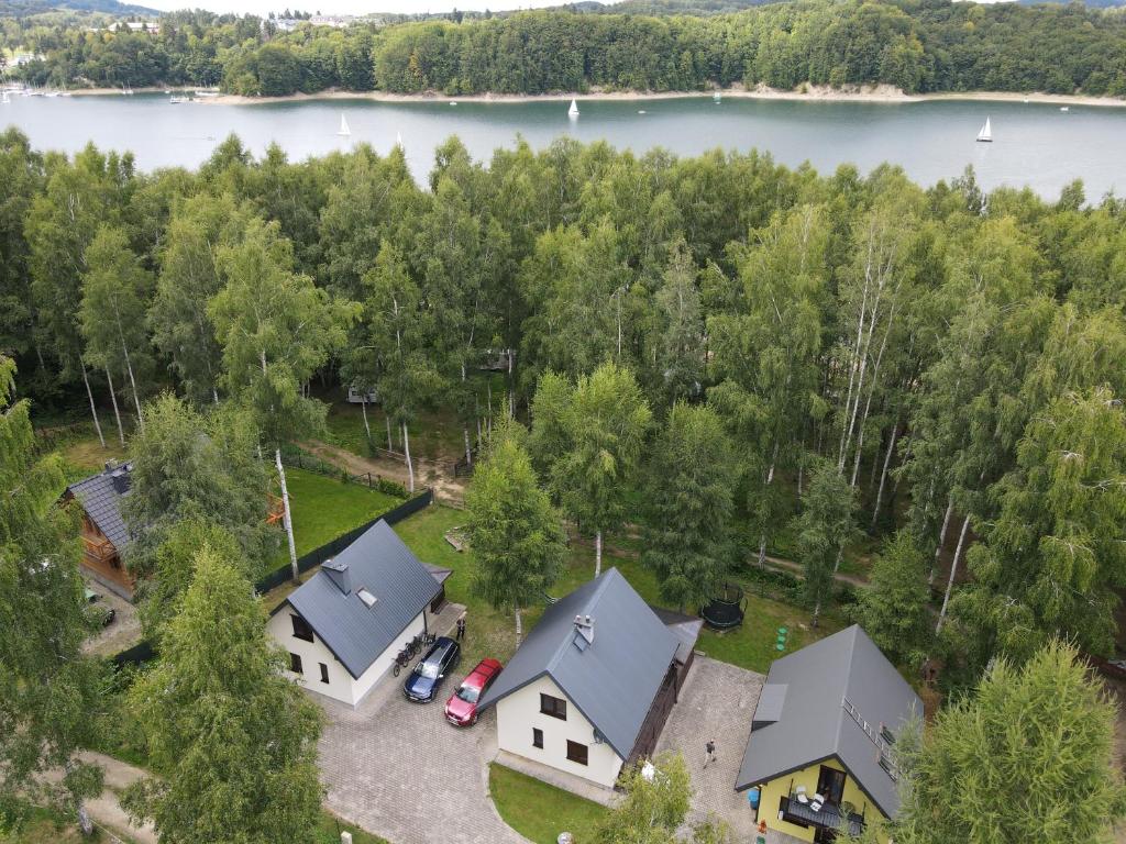 an aerial view of two houses and a lake at Cypla Czar in Polańczyk