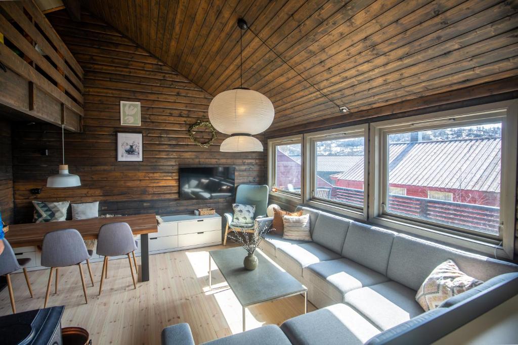 a living room with a couch and a tv at Fidjeland Holiday Home in Sinnes