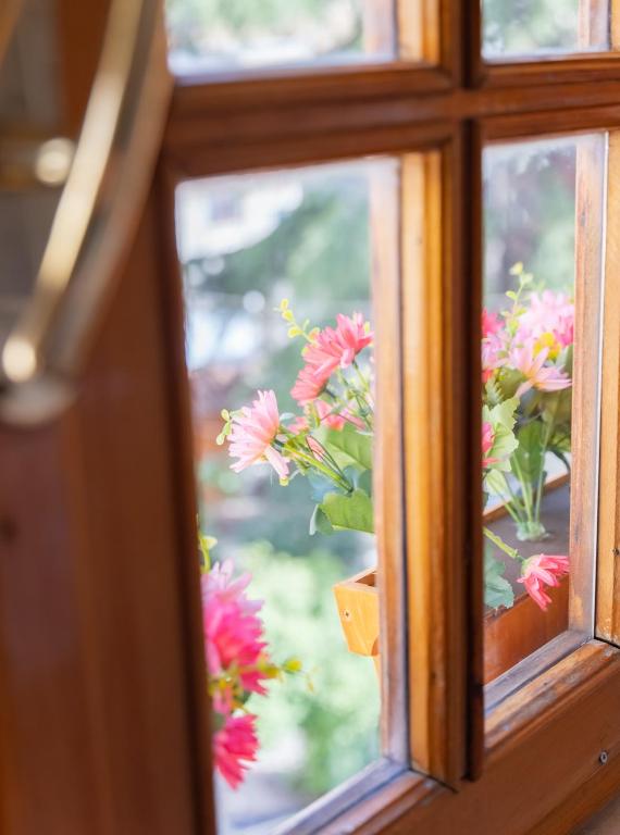 a window with a bunch of flowers in a vase at Garden Boutique B&B in Tirana