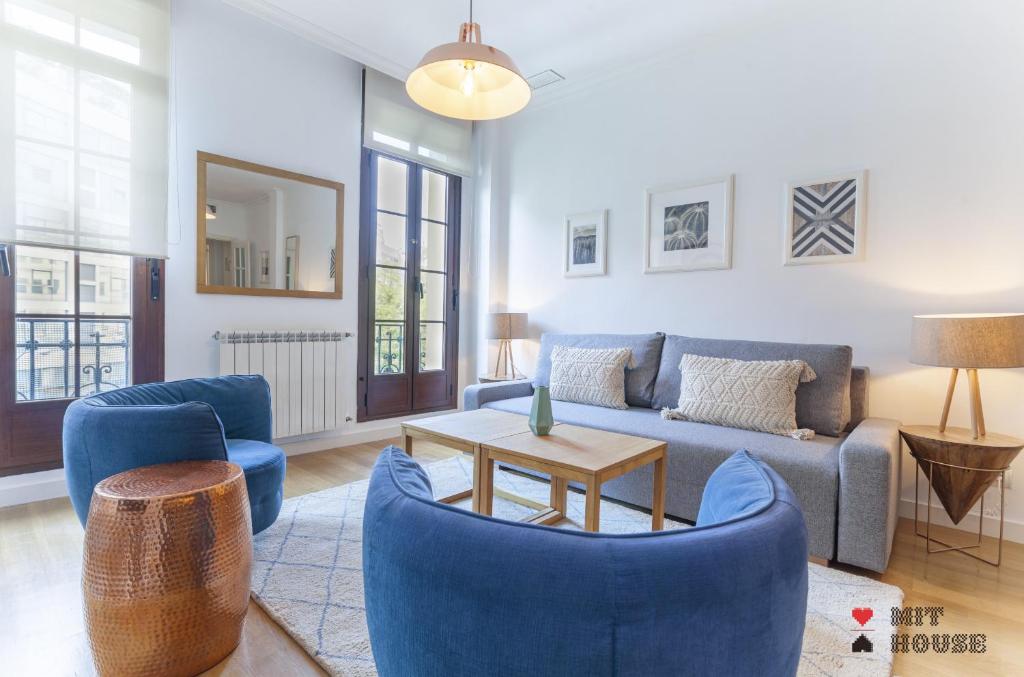 sala de estar con sillas azules y sofá en MIT House Retiro III en Madrid, en Madrid