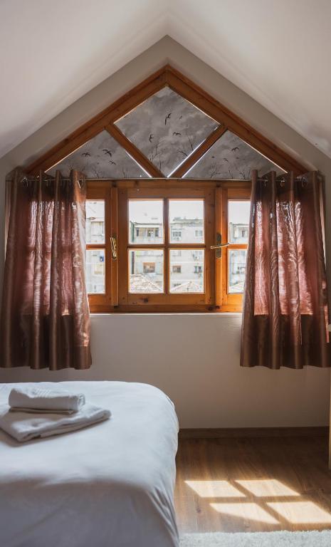 a bedroom with a bed and a window with curtains at Garden Boutique B&B in Tirana