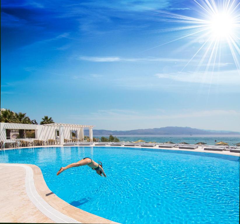 a man is swimming in a swimming pool at CHARM BEACH HOTEL in Akyarlar