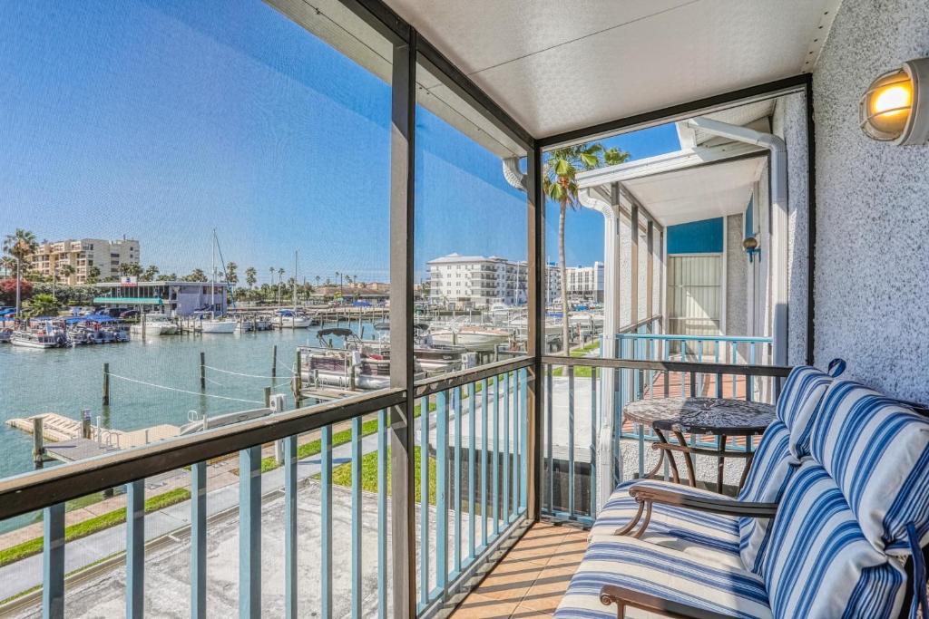 a balcony with two chairs and a view of a marina at Dockside Destiny in St Pete Beach
