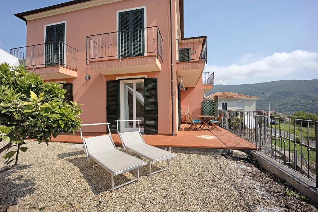 een huis met twee witte stoelen op een balkon bij Maison Laura in Diano Borello