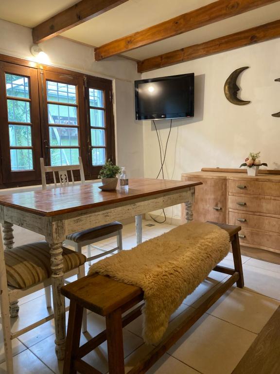 Un comedor con una mesa y un televisor. en Loft Garden's, en Rosario