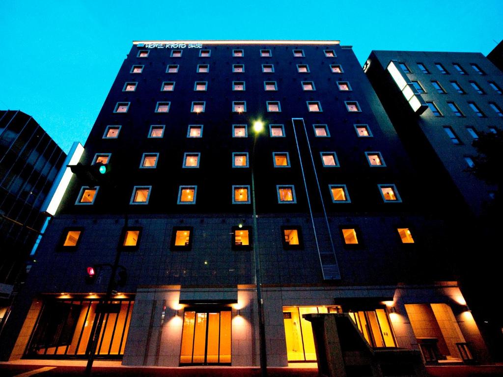a tall black building with lit windows at night at Hotel Kyoto Base in Kyoto
