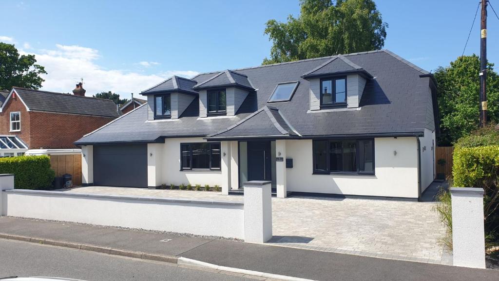 a white house with a black roof at Large modern self contained apartment in Lymington in Lymington