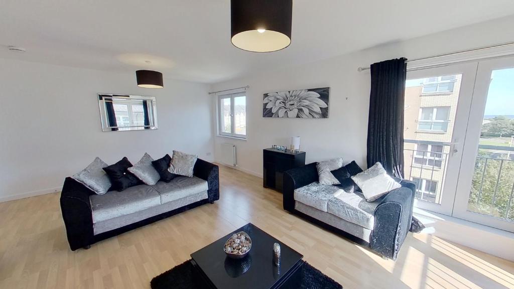 a living room with two couches and a table at Orange Apartments Bothwell Road in Aberdeen