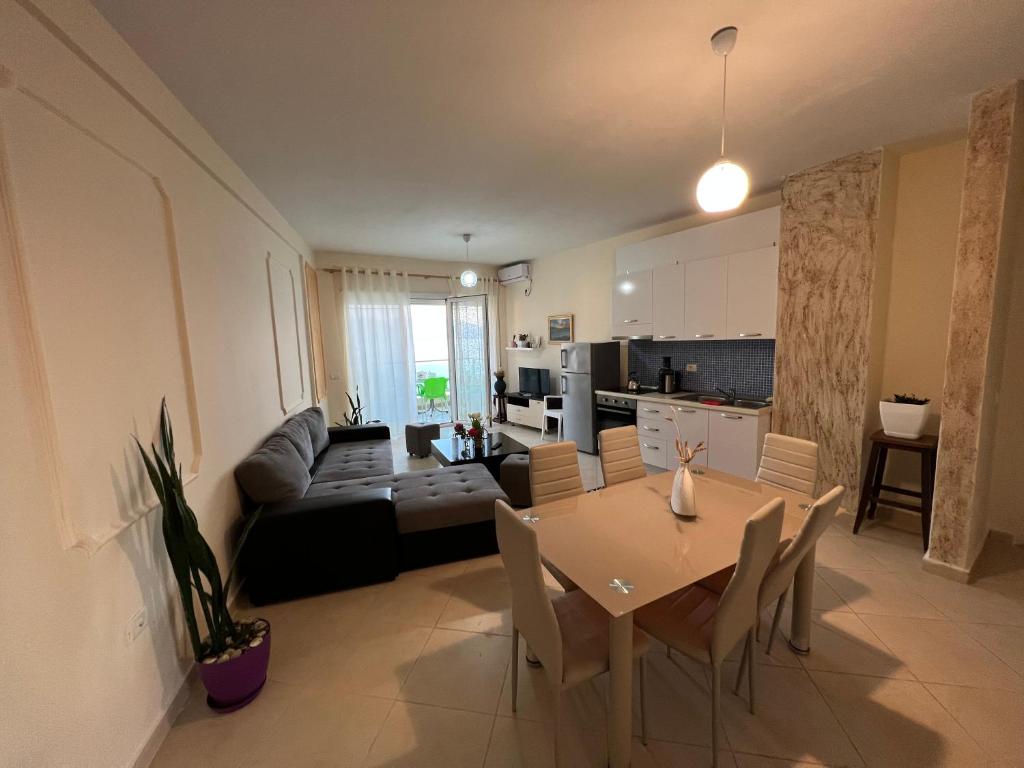 eine Küche und ein Wohnzimmer mit einem Tisch und Stühlen in der Unterkunft Hakunna Matata Residence & Apartments in Vlorë