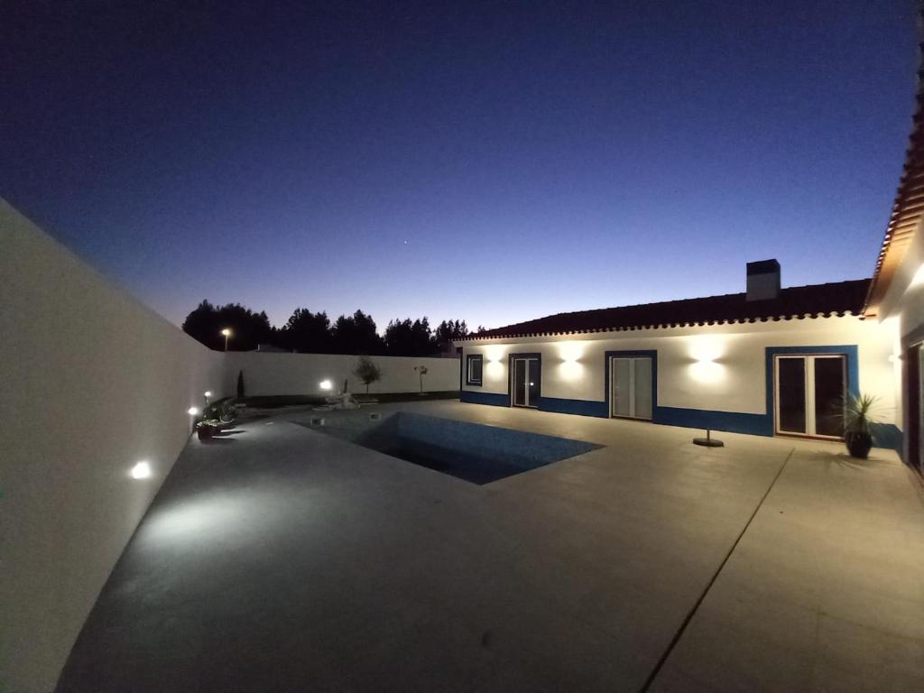 a swimming pool in the backyard of a house at night at SARDINHA BOÉMIA SUDOESTE By Stay In Alentejo in Fataca