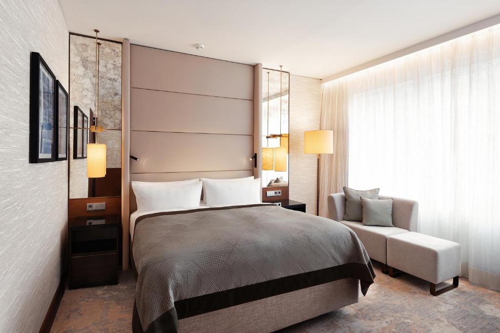 a bedroom with a bed and a couch and a window at InterContinental Berlin, an IHG Hotel in Berlin