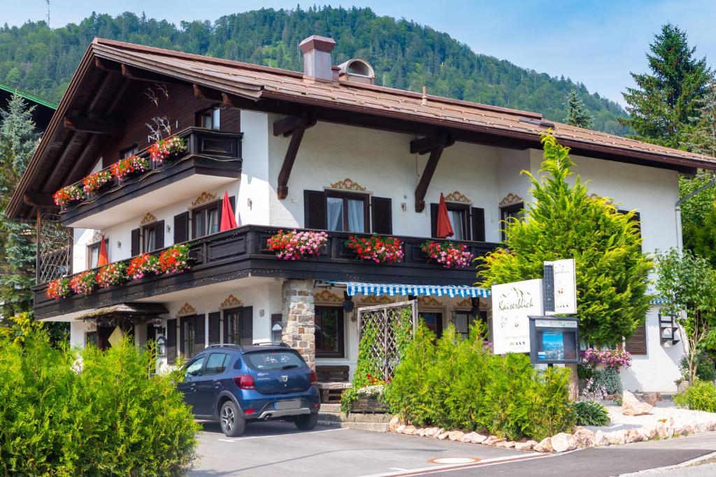 a car parked outside of a building with flowers at DEVA Hotel Kaiserblick in Reit im Winkl