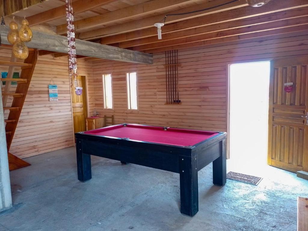 a red pool table in a room with a wooden wall at Pousada Canever in Lauro Müller