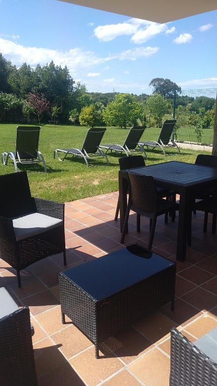 a group of chairs and tables and chairs on a patio at Apartamentos La Ardina Celorio in Celorio