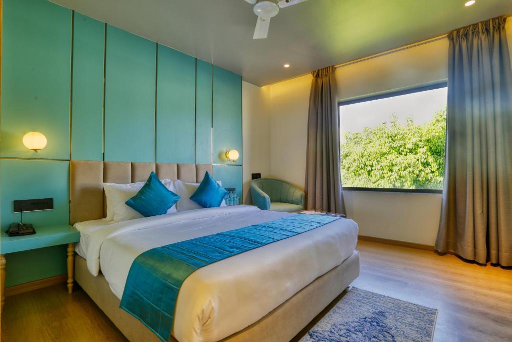 a bedroom with a large bed and a large window at The Vincent inn in Bhopal