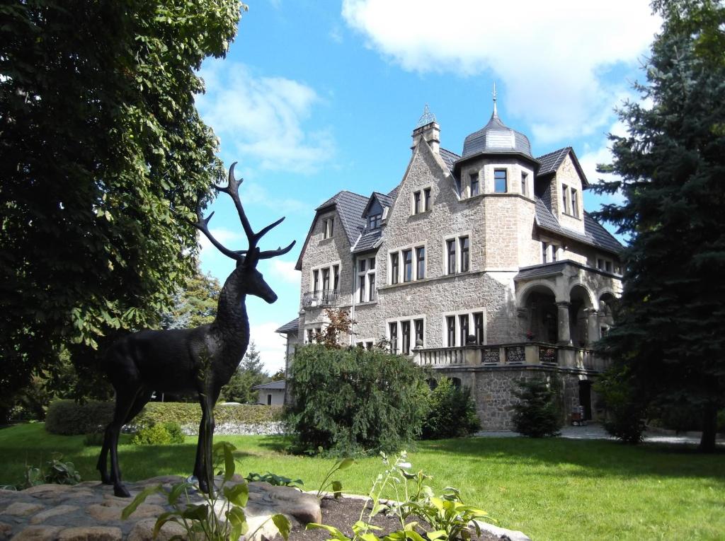 a statue of a deer in front of a mansion at Schlosshotel Stecklenberg in Thale