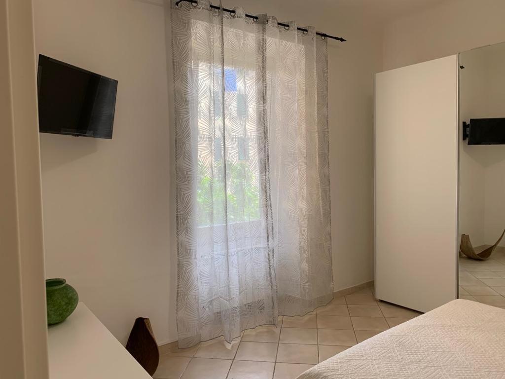 1 dormitorio con una ventana con cortinas blancas en Ca' da Màia, en La Spezia