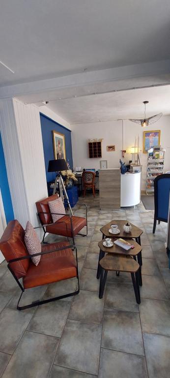 a living room with chairs and tables and a living room at Hotel Alcyon in Valras-Plage