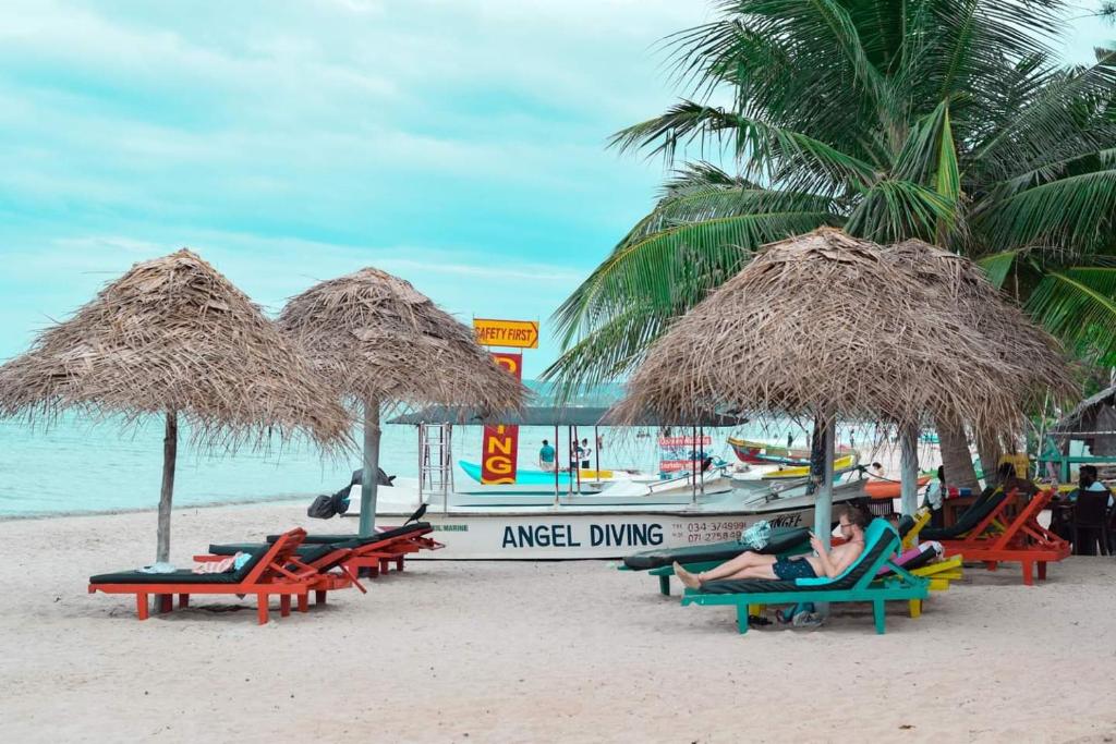 a group of people sitting in chairs on a beach at Golden Beach Cottages in Trincomalee