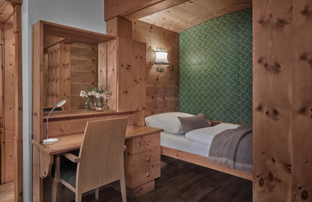 a bedroom with a bed and a desk and a desk at Hotel Goldener Greif in Kitzbühel