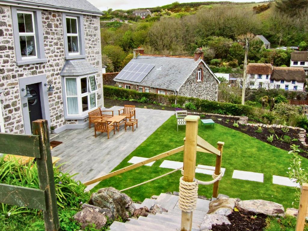 a backyard with a wooden deck and a house at Louvain in Helston