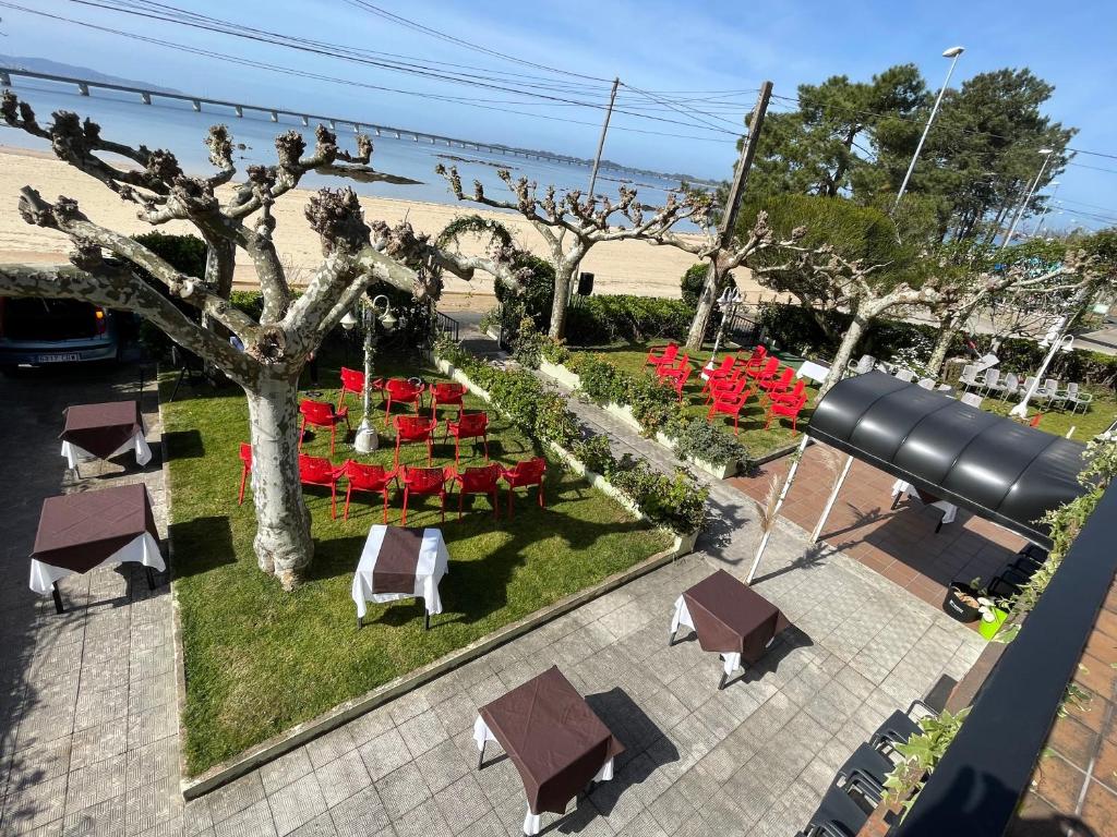 una vista aérea de un jardín con mesas y sillas en Hostal Restaurante Luz de Luna, en Villanueva de Arosa