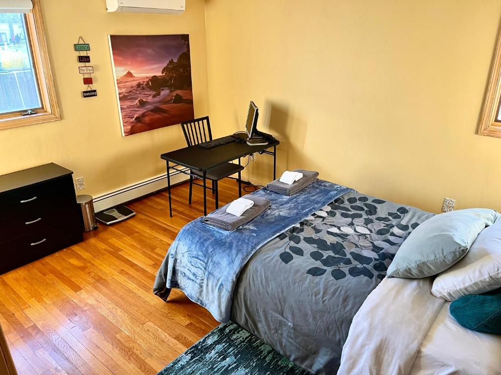 a bedroom with a bed and a desk with a laptop at Inviting room with workstation in Revere