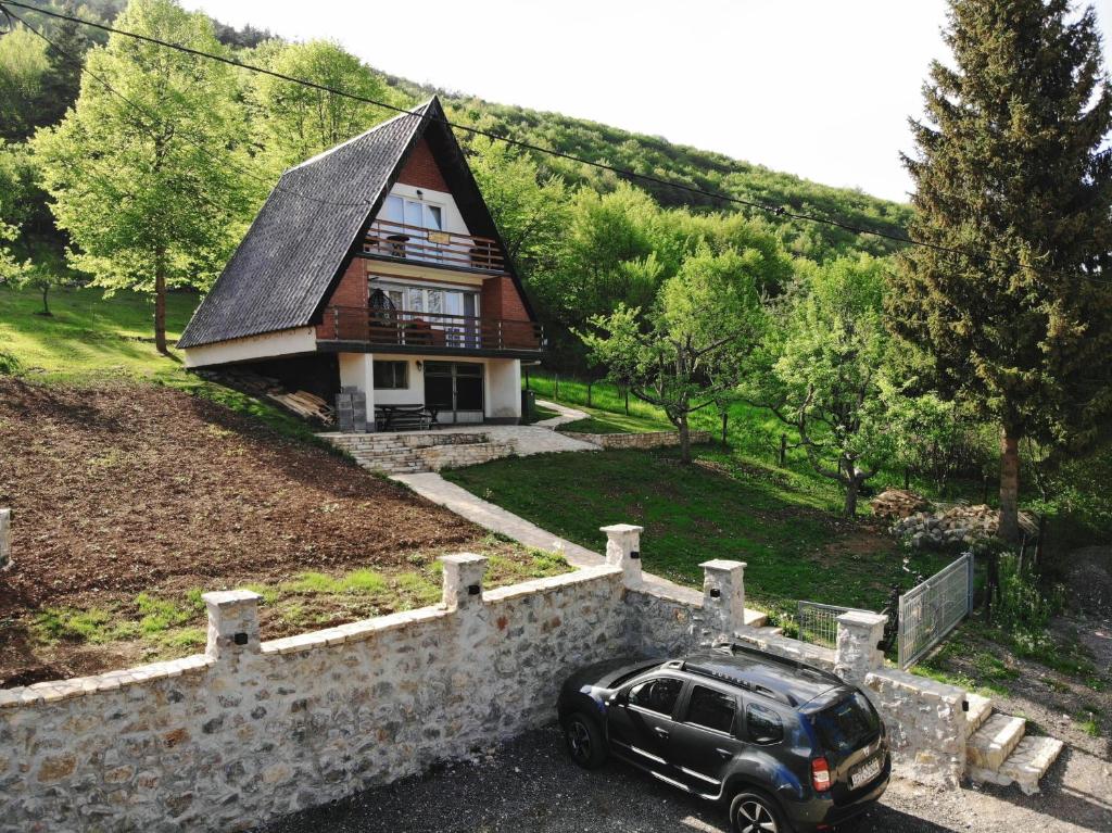 ein schwarzes Auto, das vor einem Haus parkt in der Unterkunft Apartment Stanic in Šipovo