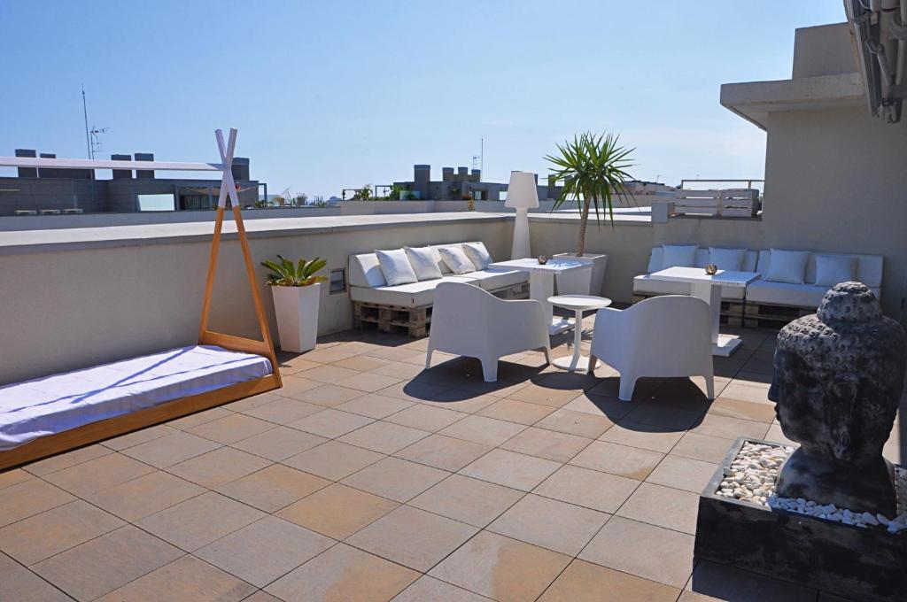 a patio with chairs and tables on a roof at Can Robert Sitges in Sitges