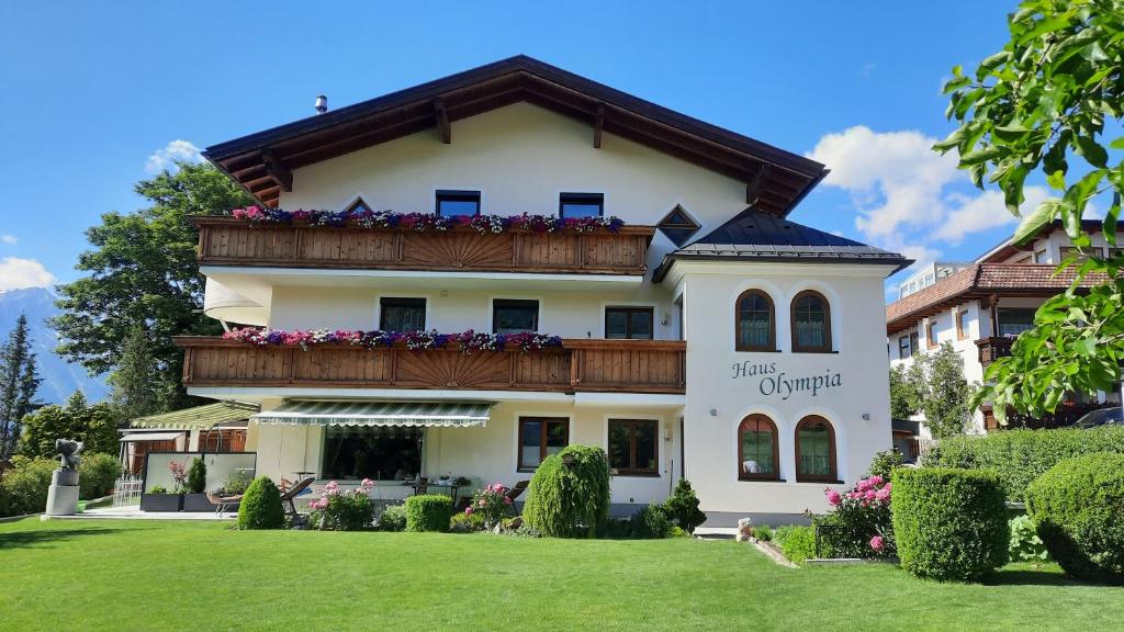 a building with a balcony with flowers on it at Appartements Haus Olympia in Innsbruck