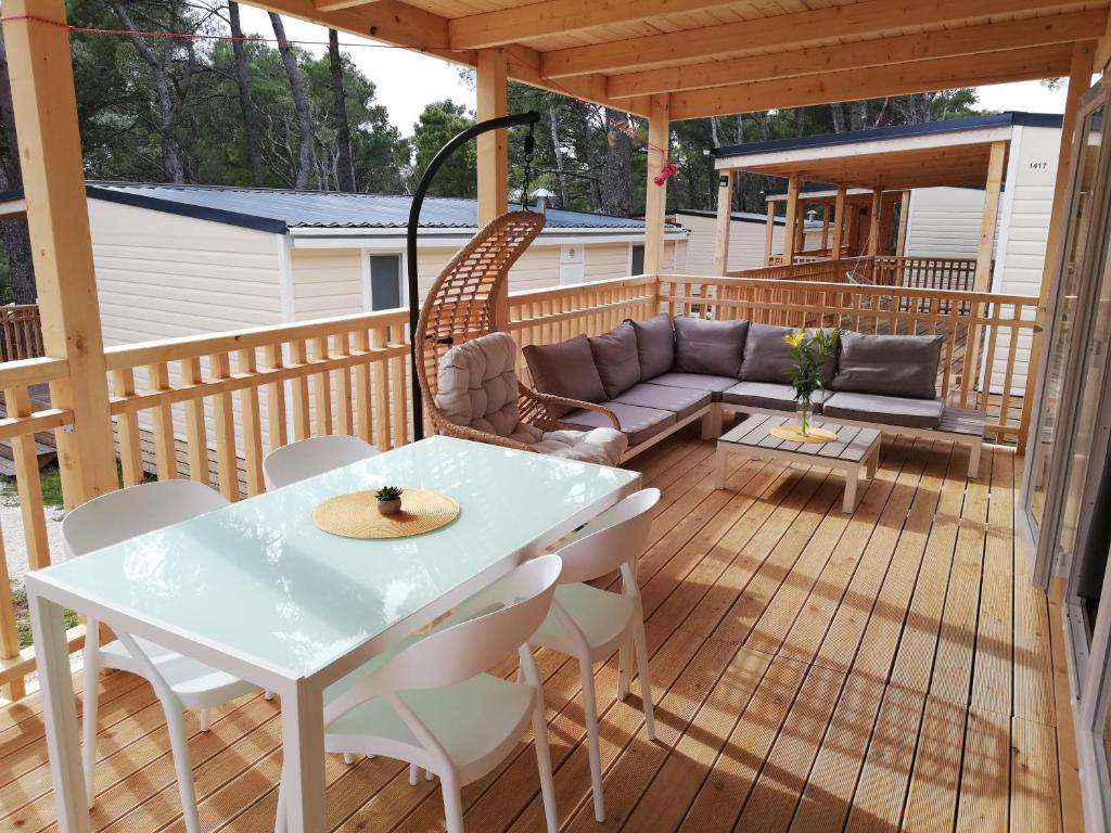 un patio con sofá y una mesa en una terraza en RELAX Mobile Home Camp Basko Polje #NEW2022, en Baška Voda