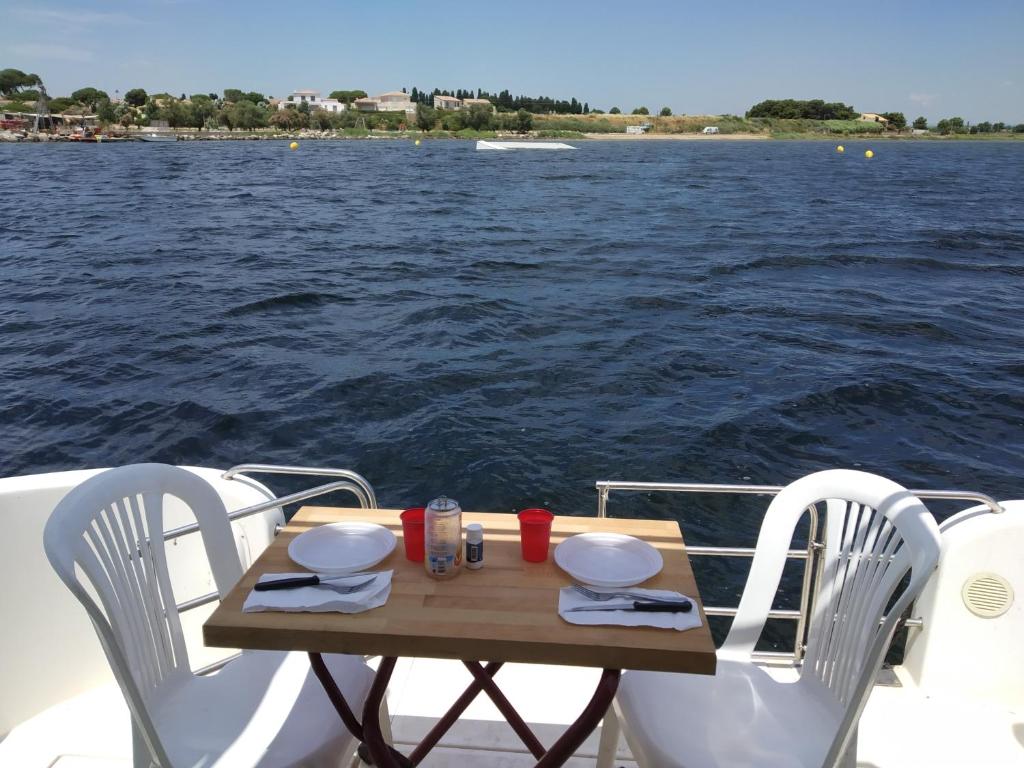 una mesa en la parte trasera de un barco en el agua en Bateau 6 personnes sans permis terrasse à quai ou option navigation, en Béziers