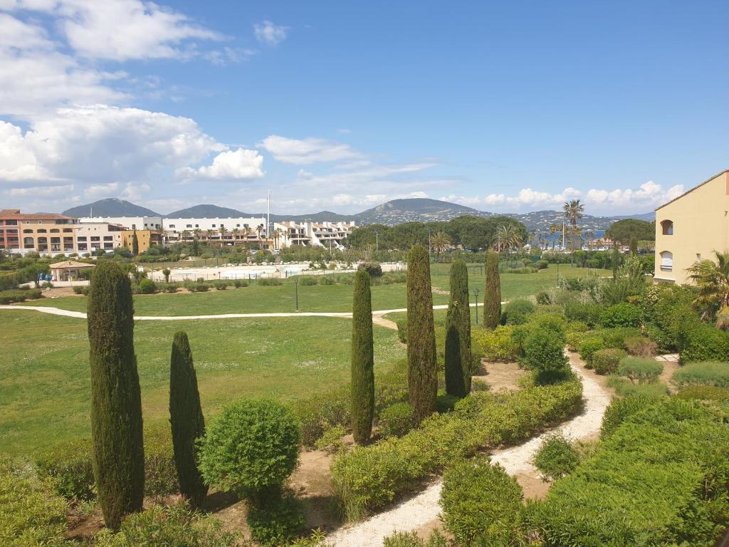 Une rangée de cyprès dans un parc dans l'établissement Superbe appartement 2 chambres piscine et plage, à Gassin