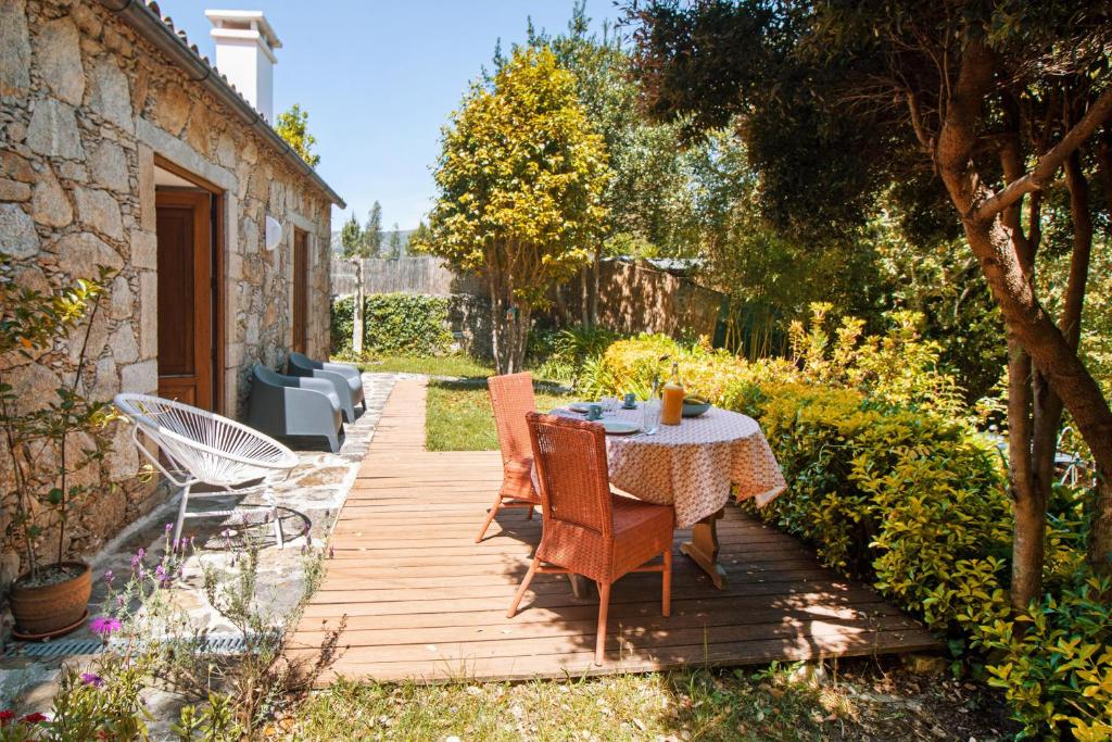 una terraza de madera con mesa y sillas. en iCHILL Villa Esquina 204 - Connected With Nature en Riba de Âncora
