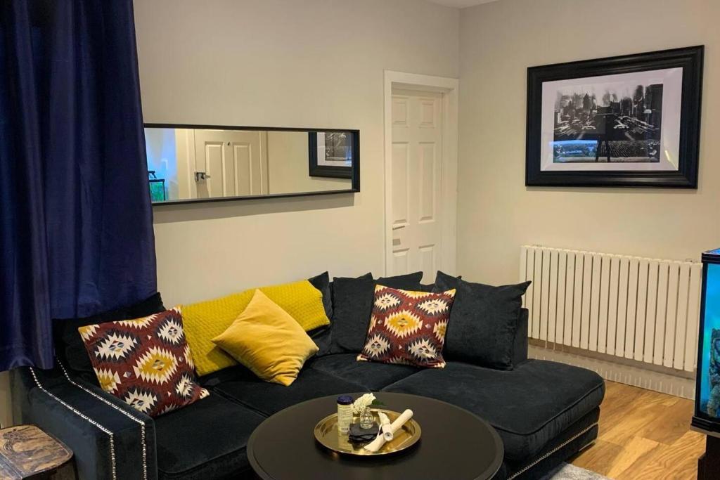 a living room with a black couch and a table at Stunning 1-Bed Apartment in London in London