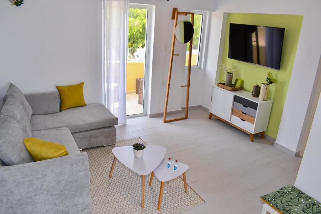 a living room with a couch and a tv at LambiSea Apartment 2 in Kos Town