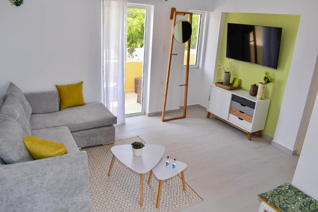 een woonkamer met een bank en een tv bij LambiSea Apartment 2 in Kos-stad