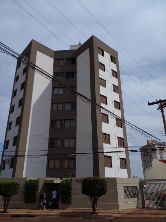 Ein großes Gebäude mit Leuten, die davor stehen. in der Unterkunft Apartamento Aconchegante com Estacionamento in Uberlândia