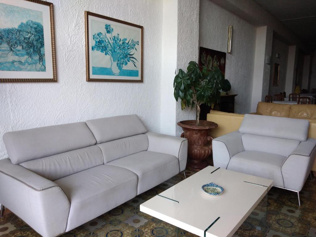 ein Wohnzimmer mit 2 weißen Sofas und einem Couchtisch in der Unterkunft Costa Azzurra in Giardini-Naxos