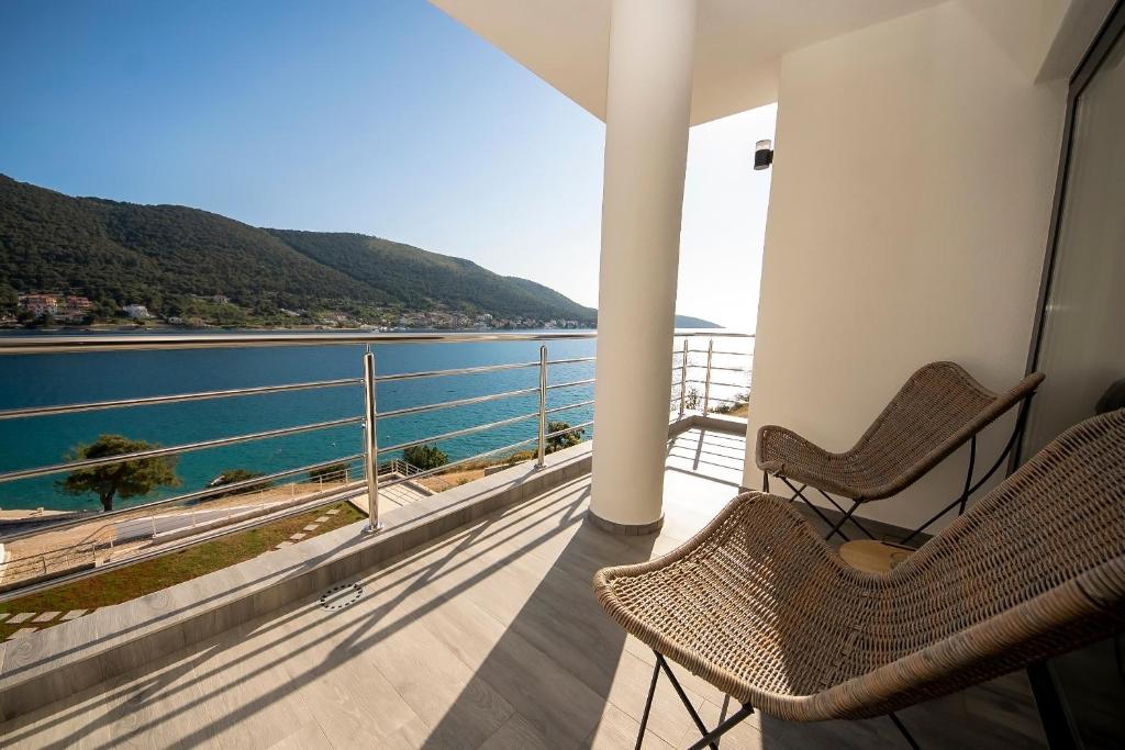 a balcony with two chairs and a view of the water at Apartments Suzy in Šibenik