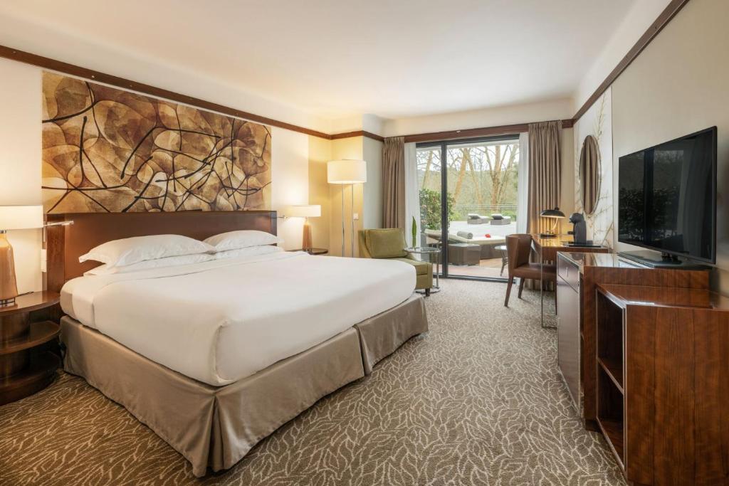 - une chambre avec un grand lit et une télévision à écran plat dans l'établissement Terra Nostra Garden Hotel, à Furnas