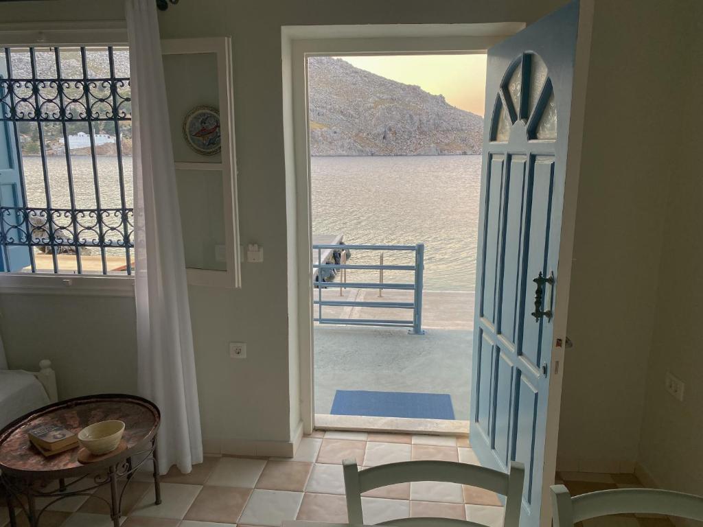 a door to a room with a view of the water at Ponente in Symi