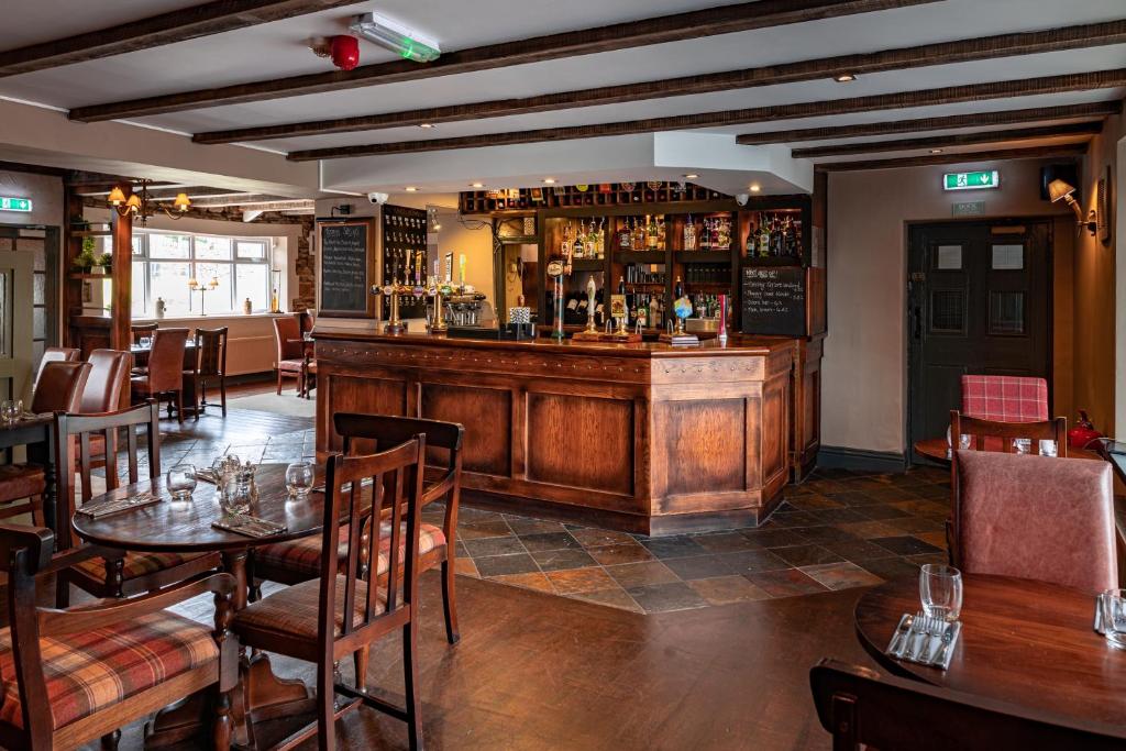 a restaurant with a bar and tables and chairs at The Derwent Arms in Edmondbyers