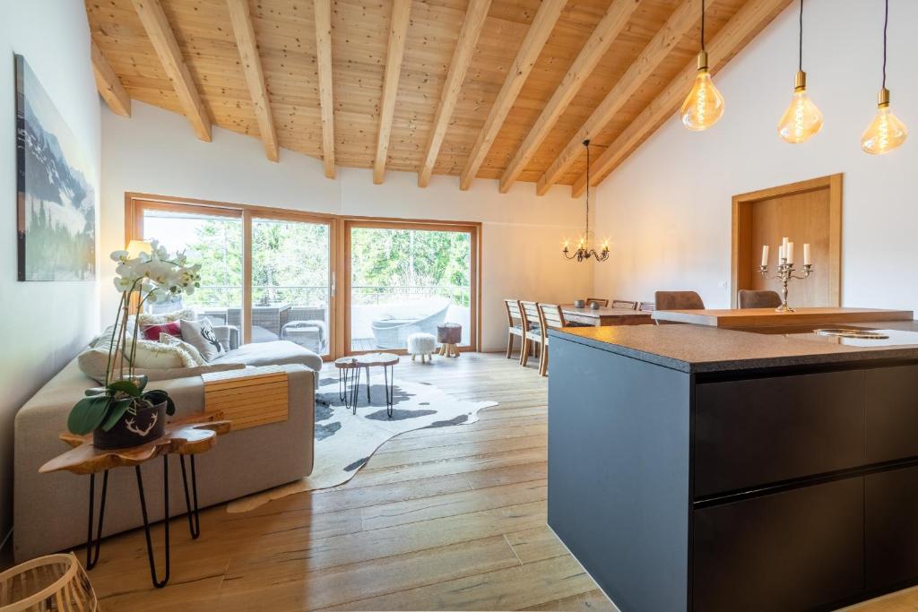 uma cozinha e sala de estar com tectos de madeira em Casa Miraselva 1-7 em Flims