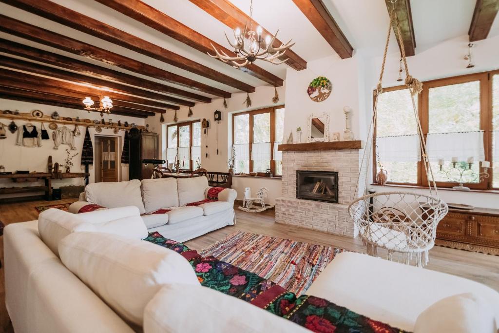 sala de estar con sofás blancos y chimenea en Casa de sub Munte, en Victoria