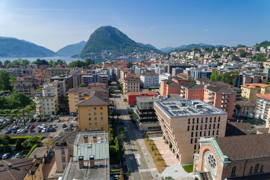 Swiss Hotel Apartments - Lugano في لوغانو: اطلالة جوية على مدينة فيها جبال في الخلفية