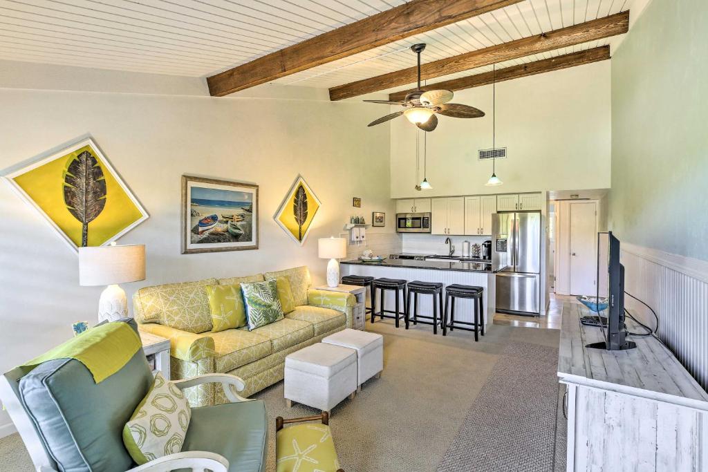 a living room with a couch and a kitchen at Coastal Condo with Pool Access Less Than 1 Mi to Beach! in Sanibel